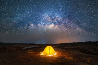 露营帐篷下的天空在山上与银河与明亮的星星在晚上在旅行的假日度假概念。自然宇宙空间景观背景。探险旅游活