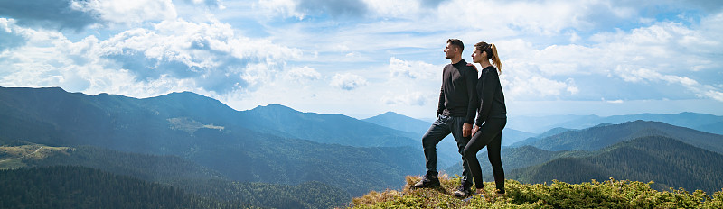 这对幸福的夫妇站在有着如画的云景的山上