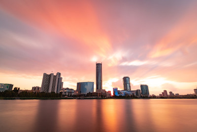 美丽的多云日落在城市池塘。长时间曝光的叶卡捷琳堡城市景观，俄罗斯与摩天大楼反映在水中