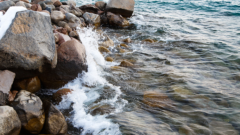 海滩上的石头。牧场的冬日。清澈的水和沙子。吉尔吉斯斯坦、吉湖