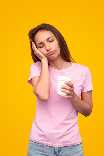 昏昏欲睡的女人和一杯充满活力的咖啡