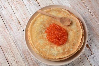 红鱼子酱煎饼。忏悔周节日大餐。一堆俄罗斯煎饼配红鱼子酱。乡村风格