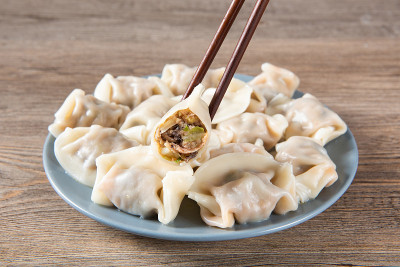 快来看看新鲜的水饺。中国食物在乡村古老的木制背景。