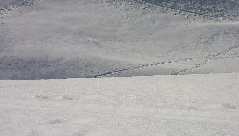 高山积雪上的登山者的足迹