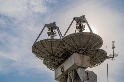 大型抛物面天线将信号发送到太空的卫星对着蓝天