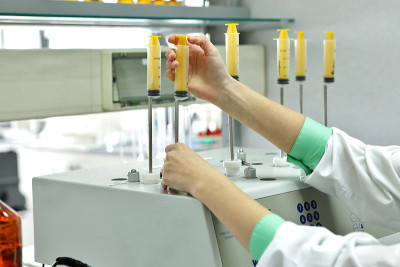 女化学家对药片和其他剂型进行溶解度测试。科学研究制药实验室。一个人在工厂里进行科学工作。实验室研究