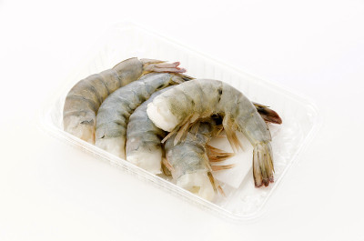 新鲜的黑虎虾尾在白色背景的塑料包装