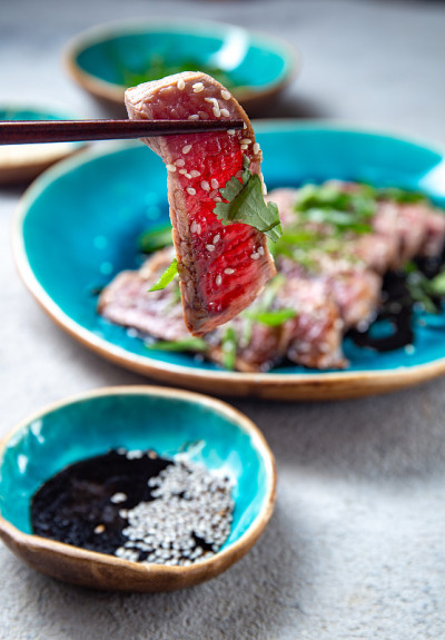 酱汁芝麻牛肉tataki蓝盘。日本食品