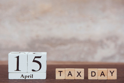 4月15日是纳税日。日历和字母木块立方体与数字在桌子上深色木板木制背景与复制空间