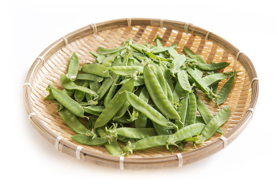竹制漏勺上的荷兰豆。