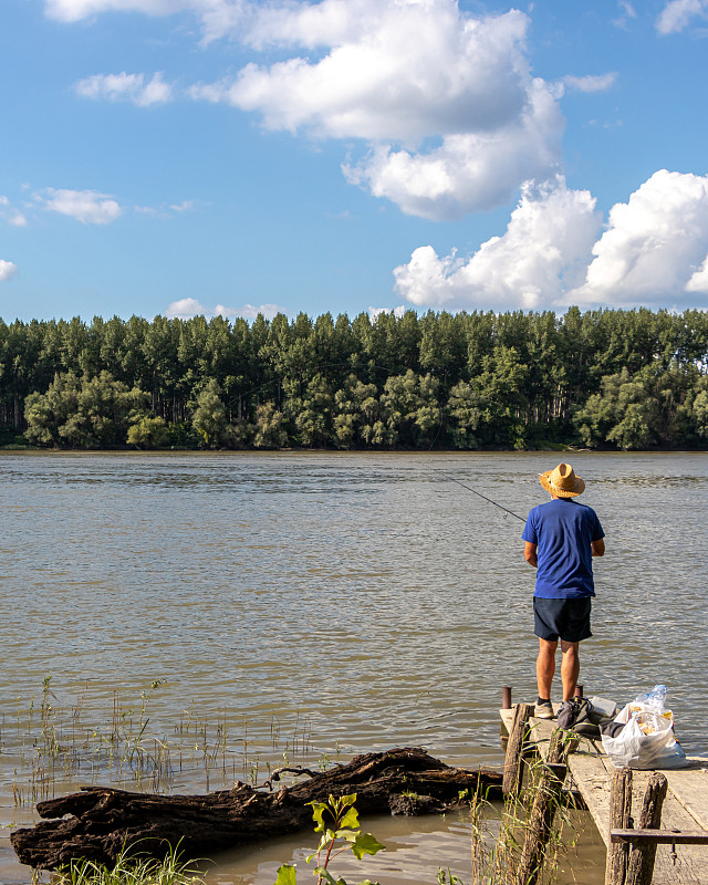 Senior man fishing with a fishing rod on the Danub