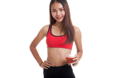 美丽健康的亚洲女孩和番茄汁。
