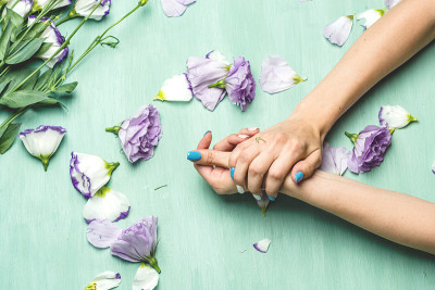 绿色背景上有花的女人的手。