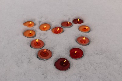 明亮的五彩蜡烛在雪地里排成心的形状