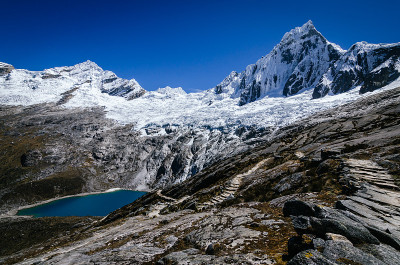 在秘鲁的圣克鲁斯奎布拉达徒步旅行中，陶里拉朱和陶里科查泻湖高雪山旁的岩石路