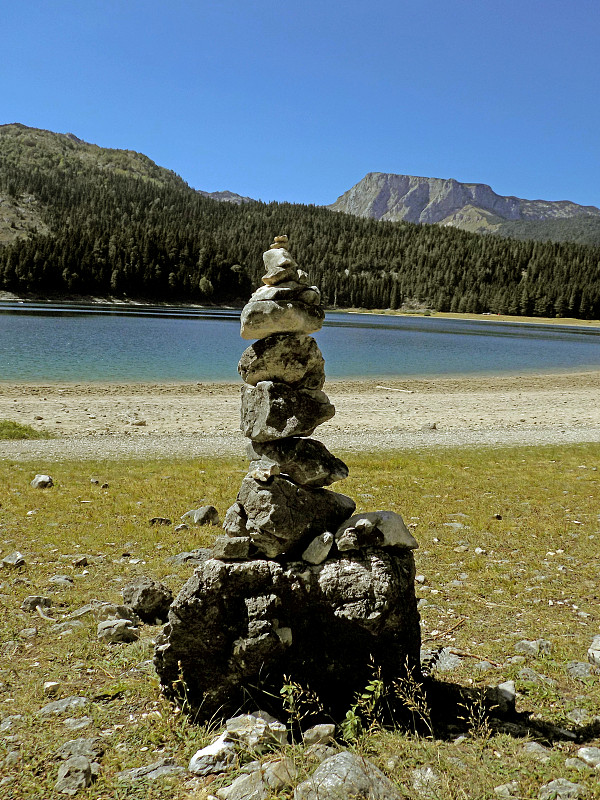 湖边山上草地上的石塔