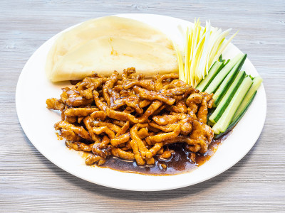 白盘子里的北京猪肉放在灰色木板上