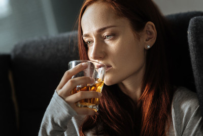 闷闷不乐的女人喝着威士忌