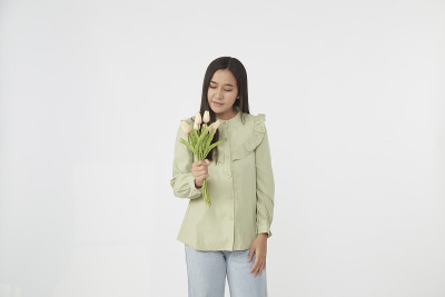 春天美丽开朗的女孩手捧一束郁金香微笑着。年轻快乐的女人。3月8日国际妇女节的惊喜。