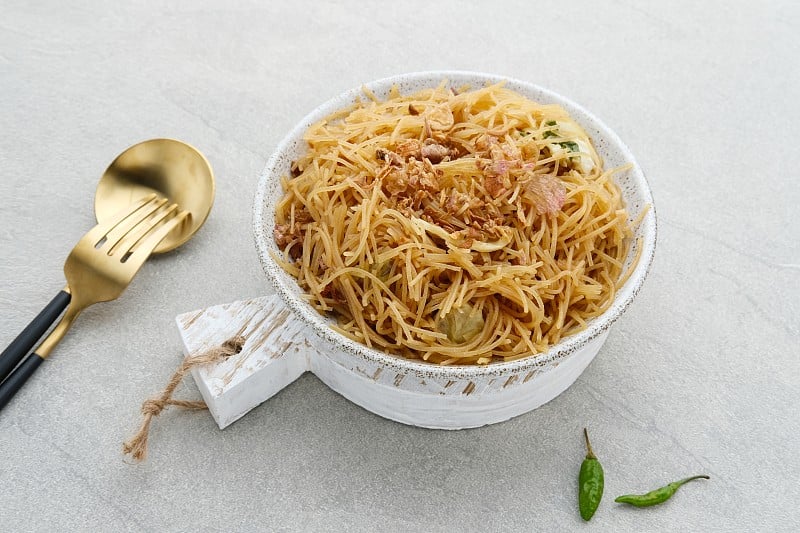 Bihun Goreng或炒饭粉丝，传统印尼烹饪食物。白色盘子，灰色背景