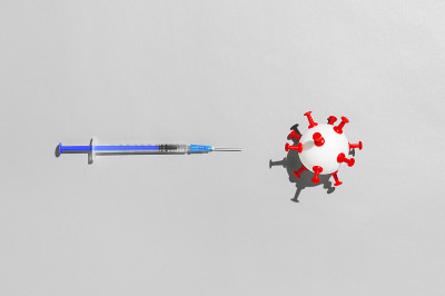 冠状病毒疫苗接种的概念。抗COVID-19疫苗医用注射器，灰色背景为白球状病毒。俯视图，平放