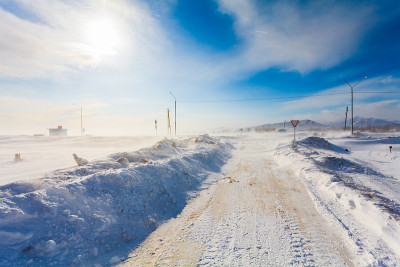在暴风雪或能见度较低的乡村道路上，有危险的雪地道路，有道路标志，用于驾驶汽车和公共交通。