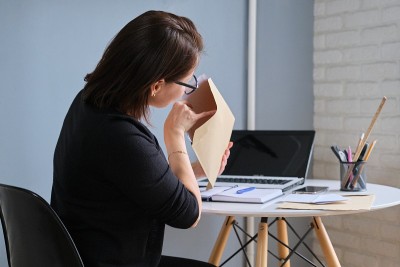 一名成年女性正在看信封里的纸质文件