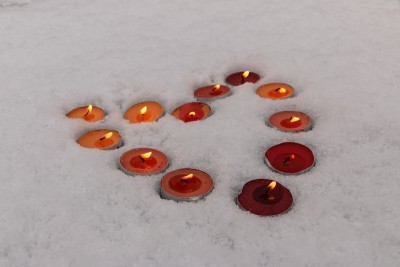明亮的五彩蜡烛在雪地里排成心的形状