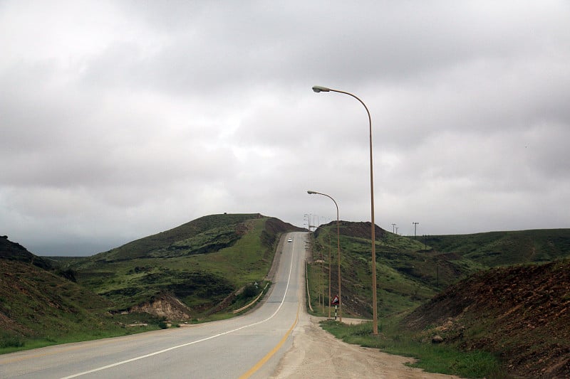 道路之间郁郁葱葱的绿色山景观萨拉赫，阿曼