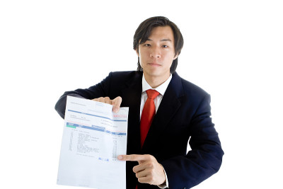 严肃的亚洲商人指出过去的医疗账单孤立