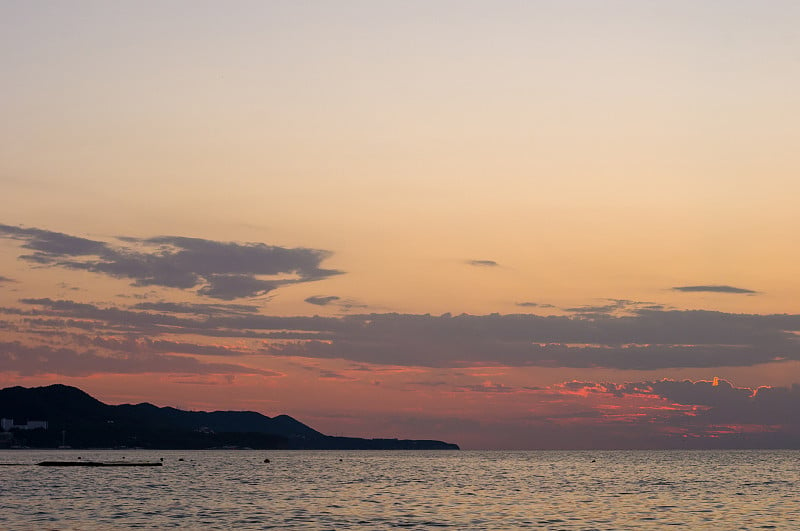 卵石滩上惊人的海上日落，太阳，海浪，云彩