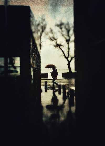一个模糊的女人撑着伞在雨中行走