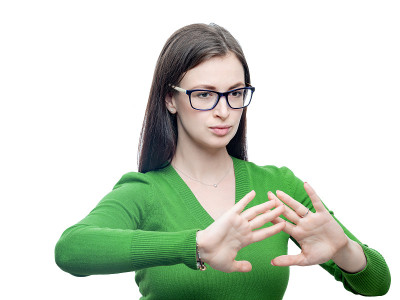 年轻的黑发女人用怀疑的表情表示拒绝。她戴着一副眼镜，穿着一件绿色的衬衫。工作室肖像孤立在白色高分辨率