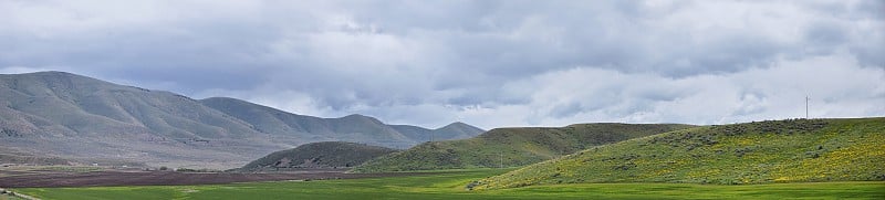 风景风暴全景从犹他州和爱达荷州的边界84号州际公路，I-84，在落基山脉与绵羊和奶牛放牧的农村农场的