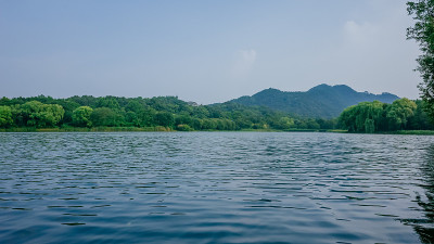 中国杭州毛家埠地区西湖的平静的水和周围的山
