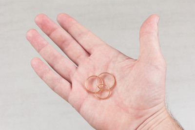 男性手掌上有三枚结婚金戒指