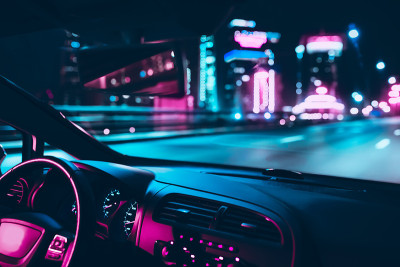 汽车在夜间城市的道路上高速行驶。复古波霓虹黑色灯光色调