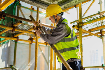 一位亚洲建筑工人正在安装脚手架