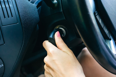 女人正在转动车里的点火钥匙。女孩开车。