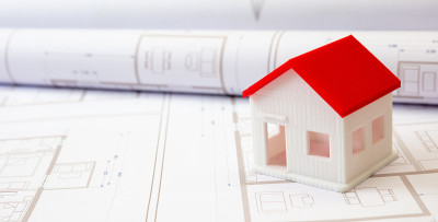建筑的概念。办公桌上有住宅建筑图纸和建筑房屋模型