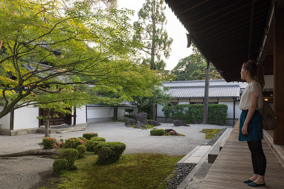 日本年轻女子看日本寺庙花园