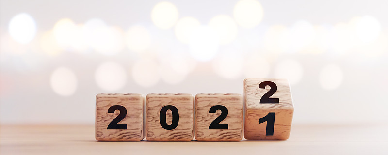 木制方块立方体在2021年到2022年之间翻转，以bokeh背景为变化和准备，通过3d渲染圣诞快乐和