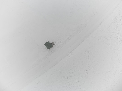 在冬日里，一架无人机在大雪纷飞的玉米田上，在浓雾中进行捕猎