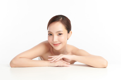 美丽年轻的亚洲女性干净清新的皮肤在白色背景，面部护理，面部护理，美容，美容和水疗，亚洲女性肖像。