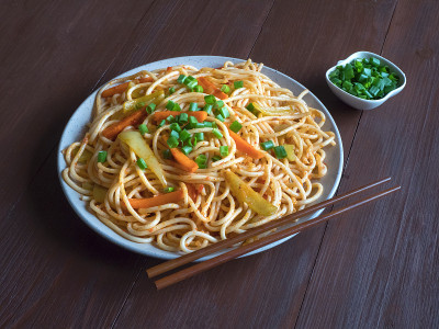 四川面条配蔬菜在盘子里。