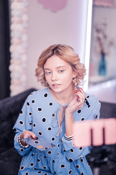 时尚的女人拿着化妆刷和化妆