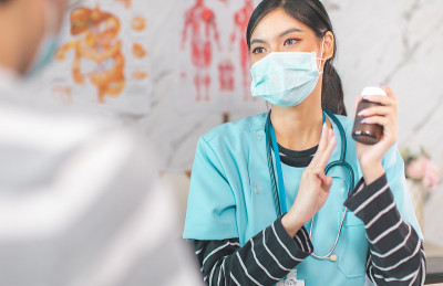 手持医生测量病人的压力。医护人员检查血压的年轻妇女期间。