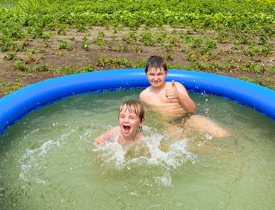 Two fair-skinned children bathe in an inflatable p