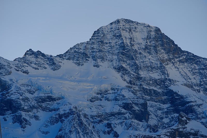 在阳光明媚的冬日，从Winteregg Mürren可以看到瑞士阿尔卑斯山脉的蒙克峰和冰川的美丽山景