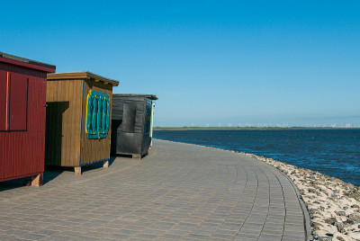 北海海岸Dagebüll海滩步道上的五颜六色的澡堂，海面平静，天空略有多云